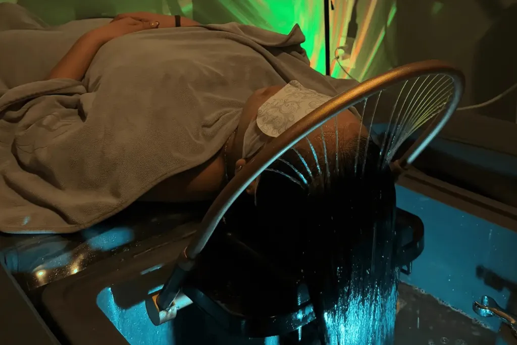 A Person Receiving A Therapeutic Head Spa Treatment With A Halo Water Ring Circulating Warm Water Over The Scalp For Deep Relaxation And Hair Health.