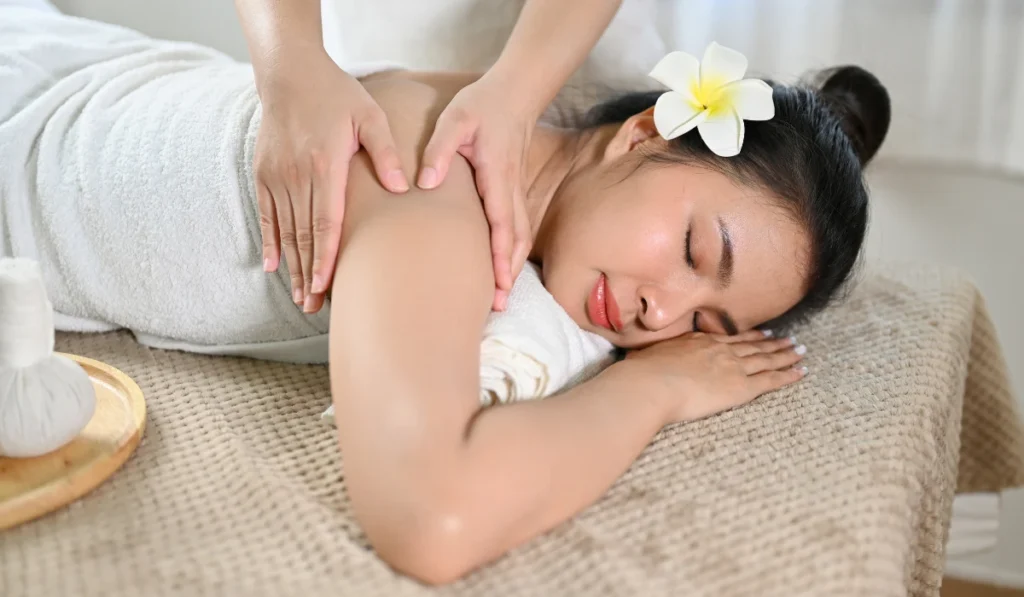Massage For Stress Relief: A Simple Guide To Calming Your Mind And Body 2 A Peaceful Woman With Closed Eyes Enjoying A Therapeutic Upper Back Massage On A Massage Table During A Day Spa Treatment.
